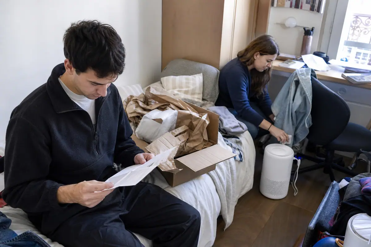 Un jeune couple déballe un petit purificateur d'air dans la chambre de son appartement