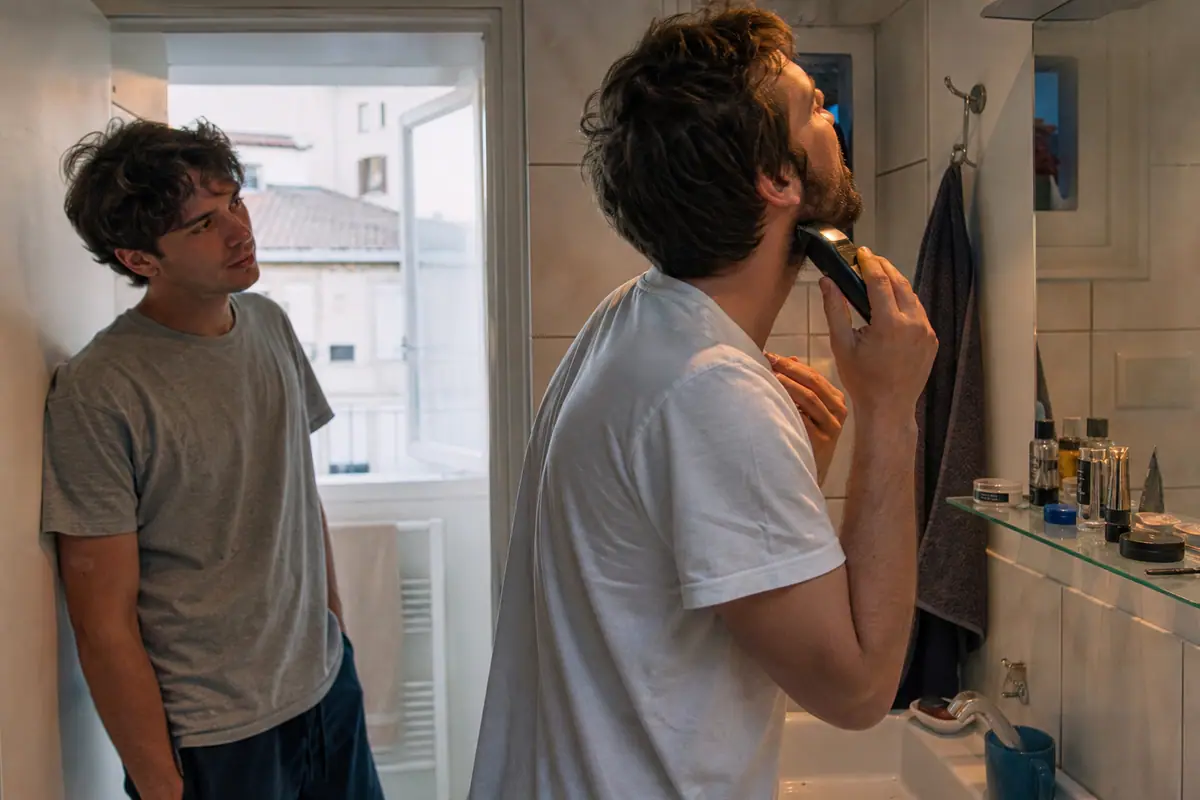 Deux jeunes hommes entretiennent leur barbe côte à côte dans la salle de bain