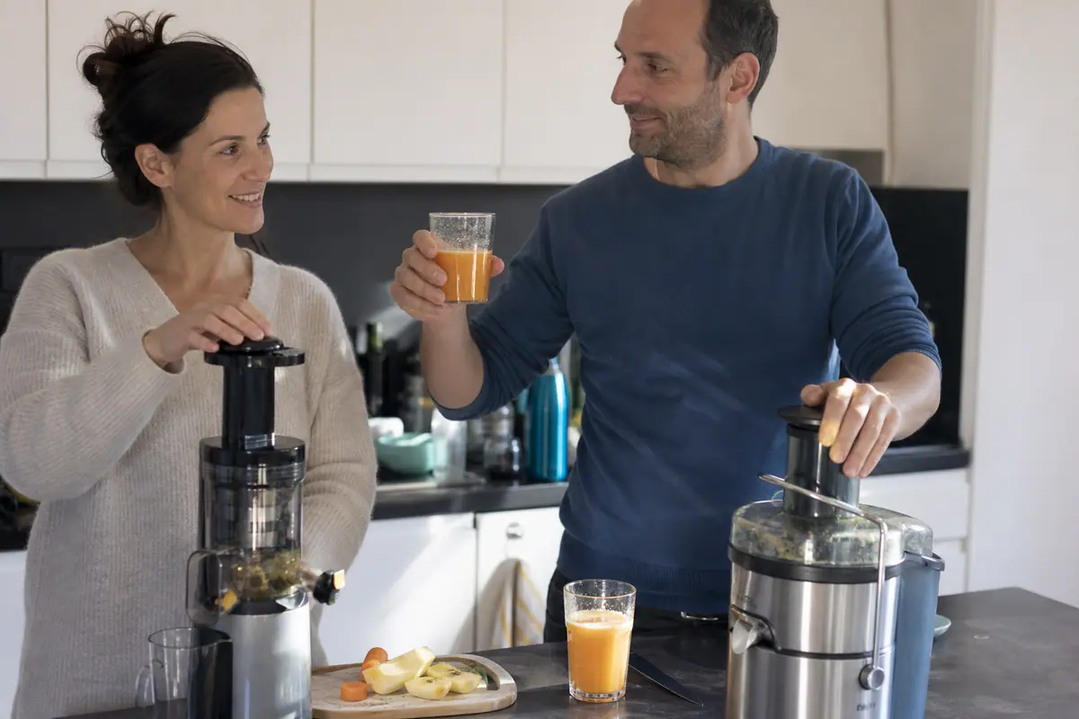 Un couple compare le jus obtenu avec un extracteur de jus et avec une centrifugeuse