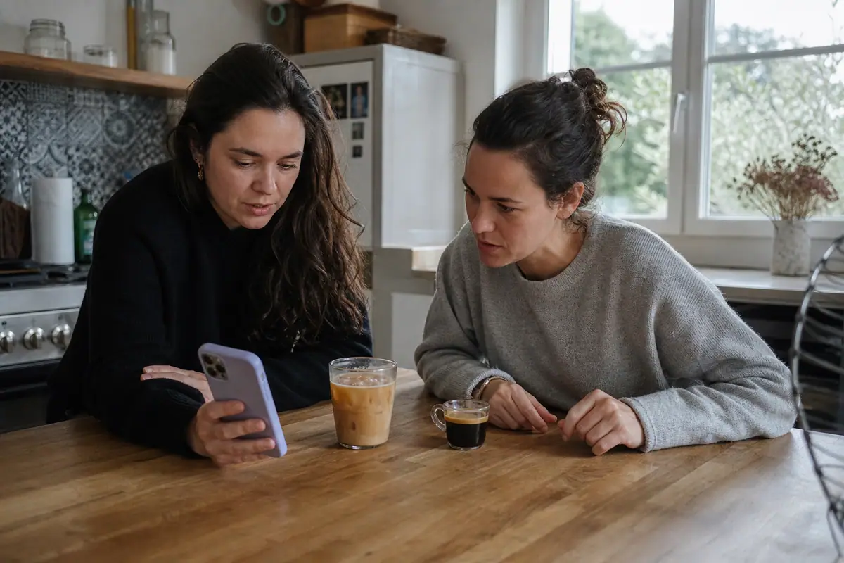 Deux amis comparent un café glacé et un espresso préparés avec deux machines à café à grain différentes