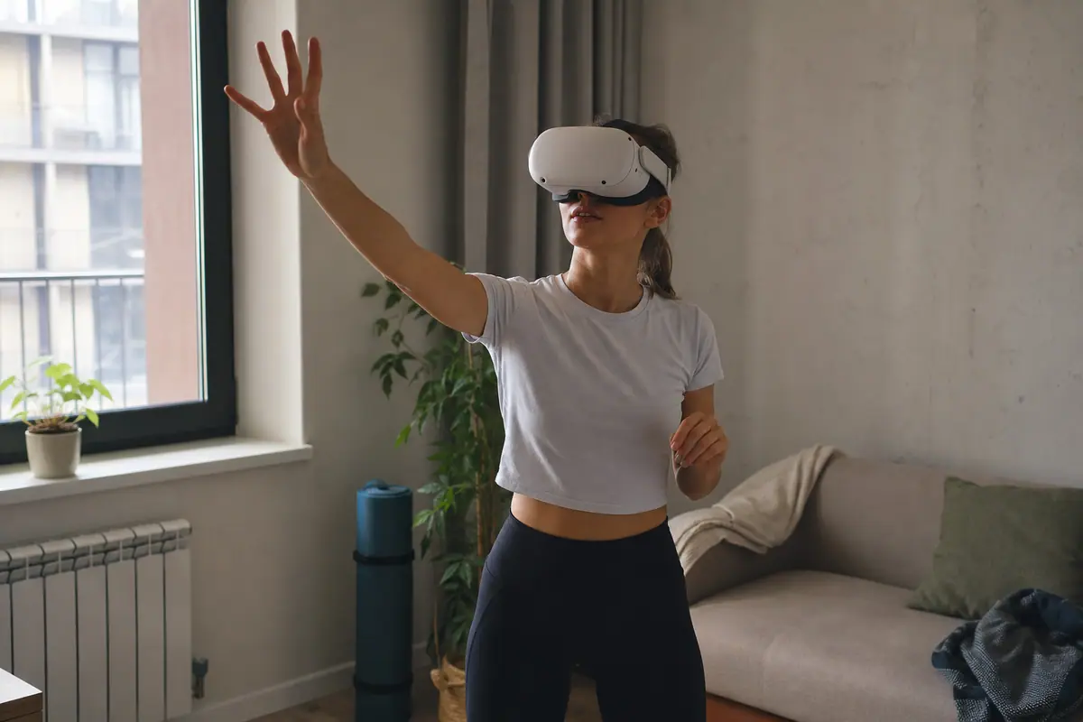 Une jeune femme joue avec un casque de réalité virtuelle autonome, sans aucun câble, dans son salon