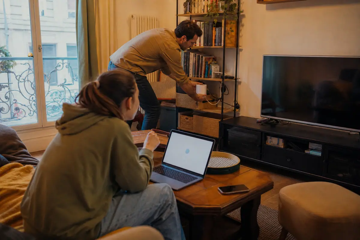 Un père et sa fille installent une borne de routeur Wifi mesh dans leur salon
