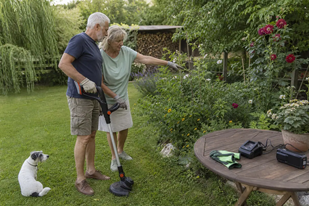 Un couple de retraités choisit ensemble comment tailler les bordures de leur jardin avec un coupe-bordure sans fil