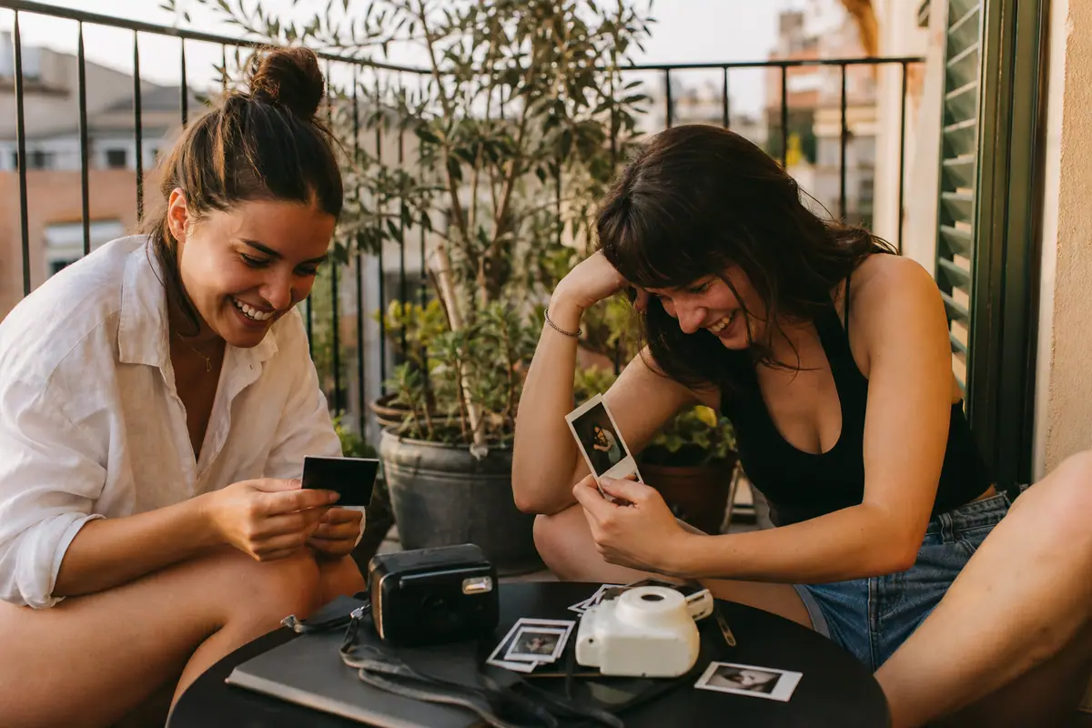 Deux amies comparent les tirages obtenus avec deux appareils photo instantanés différents